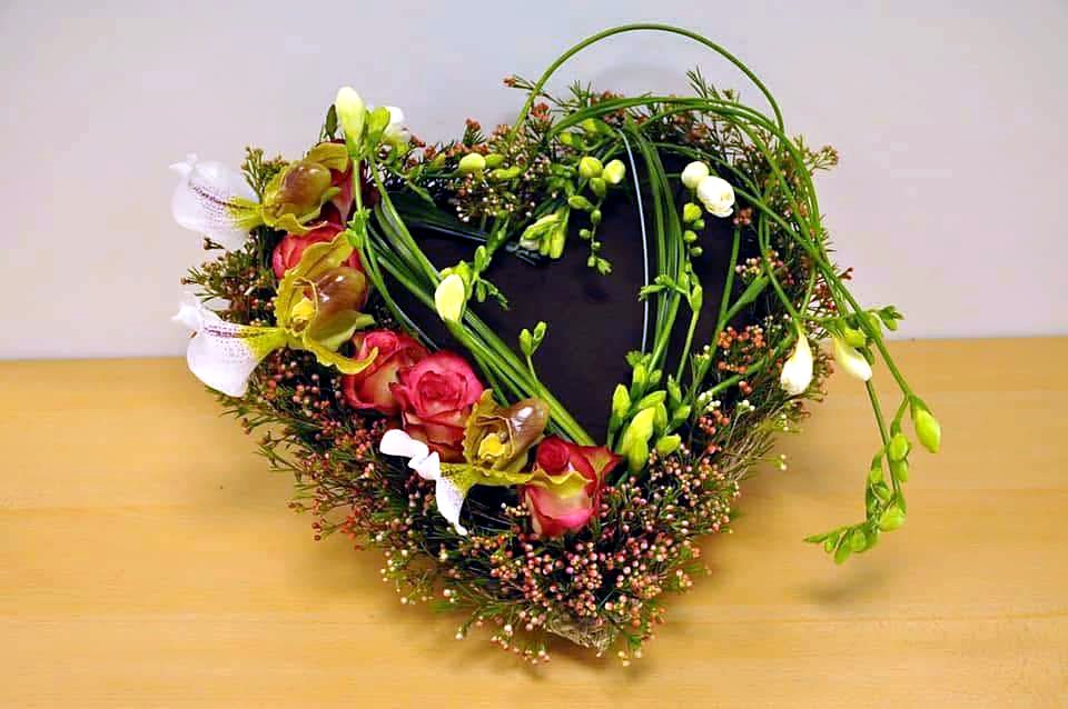 Heart-shaped sympathy wreath of moss, berries and blooms